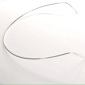 May include: A thin, flexible silver-toned metal neck wire or collar necklace. The piece features a smooth, curved, semi-circular design with slightly angled, tapered ends, creating a minimalist and open-ended structure for jewelry.