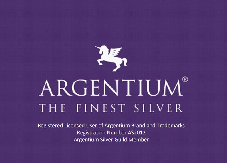 May include: A purple graphic featuring a white winged unicorn icon above the text ARGENTIUM THE FINEST SILVER. Below this, the text reads Registered Licensed User of Argentium Brand and Trademarks, Registration Number AS2012, Argentium Silver Guild Member.