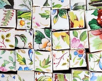 Pode incluir: Uma coleção de azulejos de cerâmica quadrados dispostos em uma grade, cada um apresentando padrões florais e botânicos distintos em várias cores, incluindo verde, amarelo, azul, rosa e vermelho sobre um fundo branco com bordas irregulares.