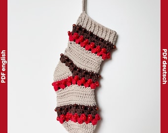 May include: A handmade crochet Christmas stocking in beige, brown, and red. The stocking features a ribbed cuff, alternating stripes, and red bead accents. The text "Crochet Pattern" is at the top.