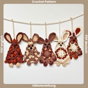 Peut inclure: Cinq ornements de lapin au crochet faits à la main dans des tons de marron et de beige sont suspendus à une ficelle. Chaque lapin a de grandes oreilles, des perles décoratives et un motif unique. Le texte "Crochet Pattern" est visible.