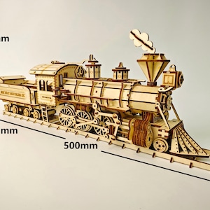 Könnte beinhalten: Ein Holzmodell eines Zuges, 50 cm lang, 17,5 cm hoch und 9,1 cm breit. Das Modell weist komplizierte Details auf, darunter Räder, einen Schornstein und einen Tender. Der Zug ist aus hellem Holz gefertigt und steht auf einem Holzgleis.