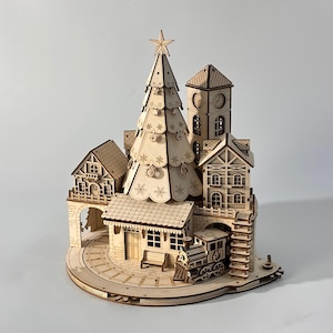 May include: A wooden Christmas village scene featuring a detailed Christmas tree, buildings, a clock tower, and a train. The scene is intricately cut from light-colored wood, with snowflake and star details.