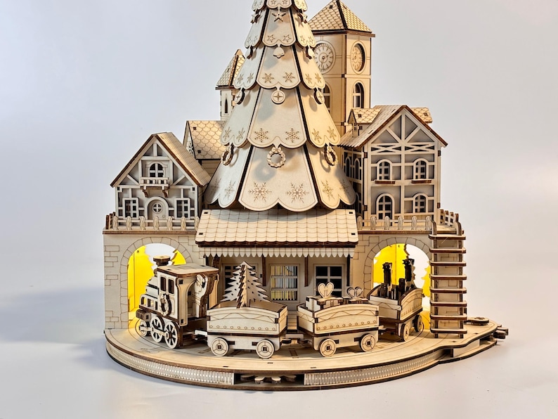 May include: A wooden Christmas village scene with a train, houses, and a clock tower. The train has several cars and is on a track. The houses have intricate details, and a large Christmas tree is in the center.