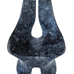 Könnte beinhalten: Abstrakte Skulptur aus dunkelgrauem Marmor mit weißen Adern. Die Skulptur hat eine einzigartige Form mit zwei hohen, gebogenen Abschnitten, die sich oben treffen, und einer abgerundeten Basis mit zwei hervorstehenden Elementen. Der polierte Stein hat eine glatte Textur.