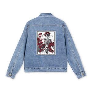 May include: A blue denim jacket with a patch on the back featuring a skeleton in a field of red roses. The patch has the text "Grateful Dead" at the bottom.