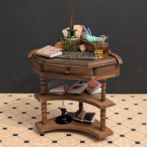 May include: Miniature wooden desk with a drawer, shelves, and turned legs. The desk is adorned with tiny books, an inkwell with a feather, a small bird figurine, and miniature bottles. The desk is made of wood and has a dark stain.