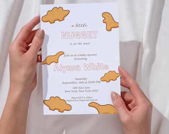 May include: A baby shower invitation with a light blue background and a pink and white font. The invitation features a cartoon dinosaur with the text "a little NUGGET is on the way!" and the name "Alyssa White".