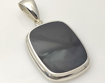 May include: A silver pendant with a black gemstone set in a square shape.
