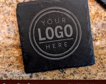 May include: Black slate coaster with a circular design that says "YOUR LOGO HERE" in a white font.