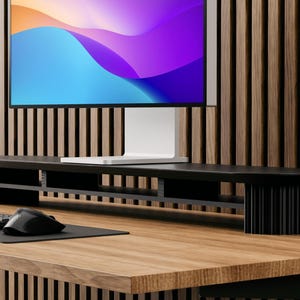 May include: Black monitor stand with multiple shelves for organizing office supplies. The stand is made of metal and has a modern design. It is sitting on a wooden desk with a computer monitor and keyboard.