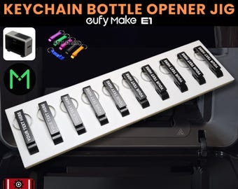 May include: A white jig with six black keychain bottle openers, each with a silver ring and the text "YOUR TEXT HERE." The jig is labeled "KEYCHAIN BOTTLE OPENER JIG" and measures 65 x 12 mm.