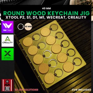 May include: A gold metal jig with 12 circular cutouts for making 40 mm round wooden keychains. The jig is labeled "40 MM ROUND WOOD KEYCHAIN JIG" and includes the names of compatible CNC machines: "XTOOL P2, S1, D1, M1, WECREAT, CREALITY". The jig is also labeled "3D JIG SOLUTIONS" and ".SVG INCLUDED".