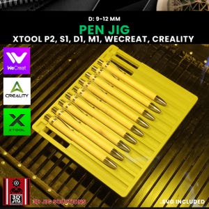 Puede incluir: Una plantilla amarilla para bolígrafos que sostiene varios bolígrafos con barriles de madera de color claro y puntas plateadas. El texto "PEN JIG" y "XTOOL P2, S1, D1, M1, WECREAT, CREALITY" son visibles. La plantilla está diseñada para bolígrafos de 9-12 mm de diámetro.