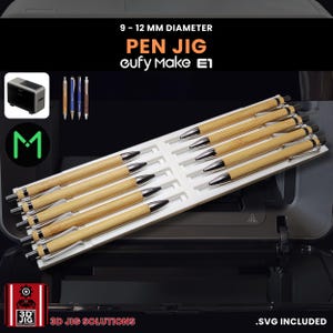 Peut inclure: Un gabarit à stylos blanc contenant plusieurs stylos. Les stylos ont un corps en bois brun clair et des détails argentés. Le texte de l'image indique "9 - 12 MM DIAMETER PEN JIG eufy Make E1" et "3D JIG SOLUTIONS".