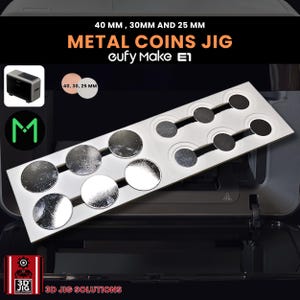 May include: A metal coins jig with the text "40 MM, 30MM AND 25 MM METAL COINS JIG eufy Make E1". The jig has circular cutouts in various sizes. The image also includes a small graphic of a 3D printer.
