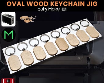 May include: A display of oval wooden keychains with silver-colored key rings. The keychains measure 31 x 48 mm. The text "OVAL WOOD KEYCHAIN JIG" is displayed above the product. The product is designed for use with a "eufy Make E1" machine.
