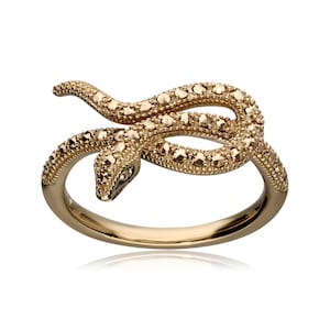 Peut inclure: Une bague en or en forme de serpent avec un design détaillé de pierres de marcassite. Le serpent est enroulé et la bague est en métal.