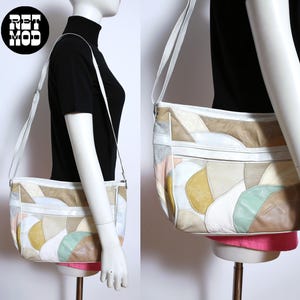 May include: A vintage patchwork shoulder bag with a white strap. The bag features a variety of pastel colors, including beige, pink, yellow, and green, arranged in a geometric pattern. The bag has a white zipper and trim. The logo "RET MOD" is in a black circle.