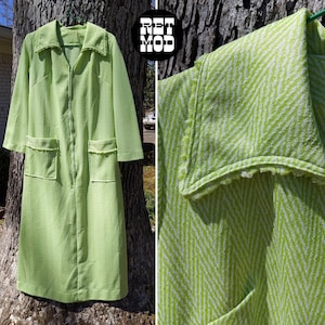 Könnte beinhalten: Ein langer grüner Morgenmantel mit Reißverschluss und zwei Taschen. Der Morgenmantel hat ein weiß-grünes Chevron-Muster und einen weißen Besatz am Kragen.