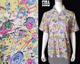 May include: A short-sleeved button-down shirt with a whimsical garden-themed print in yellow, pink, blue, and white. The shirt features a black and white checkered hem. The print includes gardening tools, hats, and flowers.
