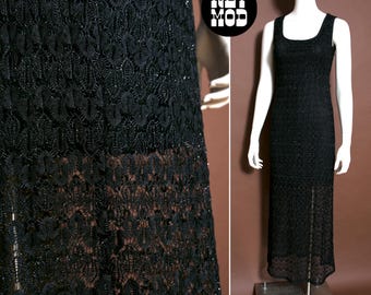 May include: A black, floor-length dress with a square neckline and a sleeveless design. The dress is made of a delicate, patterned lace fabric. The dress is displayed on a mannequin.
