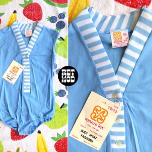 May include: A light blue sleeveless bodysuit with white stripes on the collar and down the front. The bodysuit has a button closure and is labeled "Ronnie int. Body Shirt Fashions" and "Size 10/12".