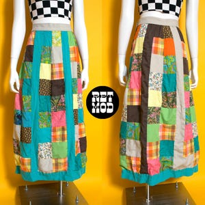 May include: A floor-length patchwork skirt featuring a variety of square fabric panels in shades of teal, orange, yellow, brown, and pink, accented with floral and plaid patterns. The skirt has a wide beige waistband and a solid teal hem.