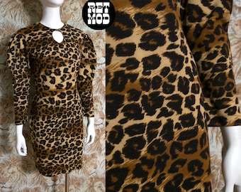 May include: A vintage leopard print dress with long sleeves and a keyhole neckline. The dress features a brown and black spotted pattern. The dress is displayed on a mannequin.