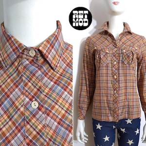 May include: A long-sleeved plaid shirt with a button-down collar and two flap pockets. The shirt is in a brown, orange, blue, and white plaid pattern.