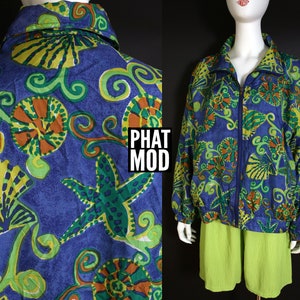 May include: A blue and green patterned jacket with a zipper closure. The jacket features a seashell and starfish design. The text "PHAT MOD" is visible on the jacket.