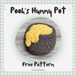 May include: A crocheted pot with a dark gray exterior and a yellow, textured interior, resembling honey. The text "Pooh's Hunny Pot" and "Free Pattern" are displayed on the image, along with the creator's handle.