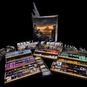 May include: A board game organiser set for Europa Universalis featuring a tall vertical storage tower with a printed historical scene, multiple tiered wooden trays, and various compartments filled with colourful plastic tokens and card decks.