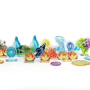 Puede incluir: Un conjunto de 14 piezas de juego de acrílico que representan varios elementos, incluyendo fuego, agua, tierra y aire. Las piezas son translúcidas y tienen diseños coloridos.
