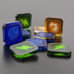 May include: A collection of square, translucent acrylic tokens in blue, green, and amber colors. Each token features a distinct etched graphic, including lightning bolts, fish symbols, and geometric shapes, with beveled edges and a polished finish.