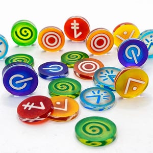 May include: A collection of circular, translucent acrylic tokens in various colors including red, orange, yellow, green, and blue. Each token features a distinct white graphic symbol, such as spirals, power icons, targets, and geometric shapes.