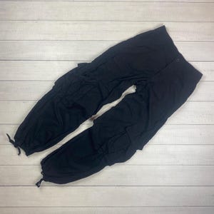 May include: Black cargo pants with multiple pockets and a drawstring waist.