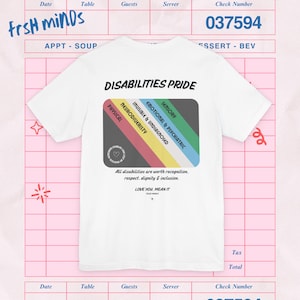 May include: A white t-shirt featuring the text DISABILITIES PRIDE above a rectangular graphic with diagonal stripes in red, yellow, blue, and green. The graphic includes labels for physical, neurodiversity, invisible, emotional, and sensory.