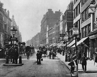 May include: A black and white historical photograph of a busy London street scene featuring horse-drawn carriages, double-decker buses, and pedestrians. Signs for Henekeys Old Wine House are visible on the buildings lining the street.