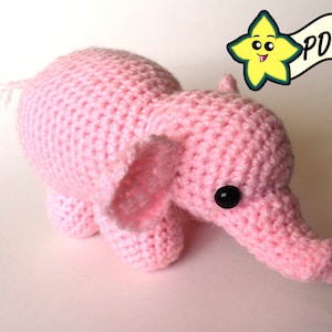 May include: A pink crocheted elephant toy with black button eyes.