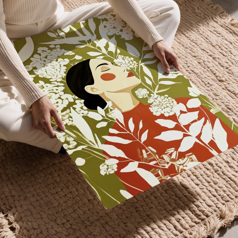 Vertical botanical portrait of a serene woman in side profile with closed eyes, black hair in a low bun, warm orange cheek and red lips, surrounded by cream flowers and leafy branches against an olive green background.
