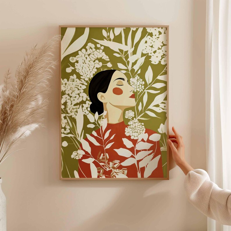 Earthy green and terracotta red portrait of a woman in quiet reflection. Her black hair is gathered into a low bun while pale floral branches curve around her face, neck, and shoulders.