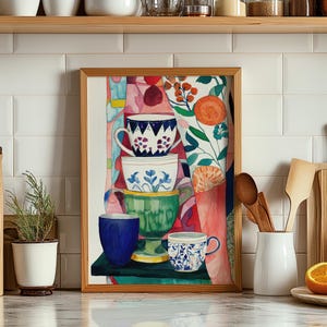 Colorful watercolor illustration of stacked teacups arranged in a playful still life. Each ceramic cup features unique floral detailing, painted with expressive textures. The surrounding abstract background includes botanical forms and layered colors, evoking a cozy and creative kitchen atmosphere.