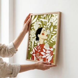 Modern floral artwork showing a woman resting among oversized leaves and blossoms. Olive green, cream, terracotta red, black, and soft beige create an earthy palette with bold graphic contrast.