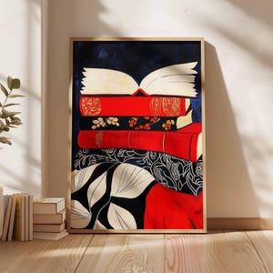 May include: A stack of colorful books with a red, white, and black patterned fabric underneath. The books are arranged in a pile with the top book open and the pages fanned out. The background is a dark blue.