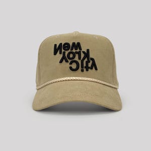 May include: Tan corduroy baseball cap with the text "VIC KLOY WEM NEW YORK CITY" in black, embroidered on the front. The cap has a curved brim and a rope detail along the base of the crown.