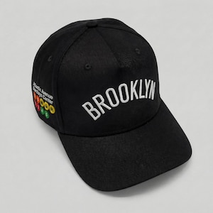 May include: A handmade wooden sign with the text "Welcome" in a playful font. The sign is painted white with a distressed finish, and features a decorative floral design in shades of pink and green. It measures approximately 12 inches wide.