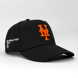 May include: Black baseball cap with an orange embroidered "NY" logo. The cap has a curved peak and a button. The text "Mets-Willets Point Station" is printed on the side, with a number 7 logo.