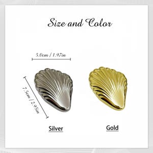 Puede incluir: Un objeto decorativo en forma de concha plateada y dorada. La concha plateada mide 7,5 cm de largo y 5,0 cm de ancho. La concha dorada es de tama&ntilde;o similar. Tambi&eacute;n est&aacute; presente el texto "Size and Color", "Silver" y "Gold".