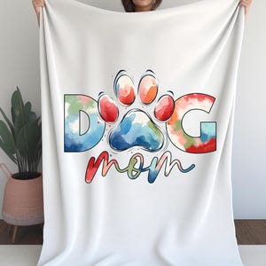 May include: White fleece blanket with a colorful watercolor paw print and the text "Dog Mom".